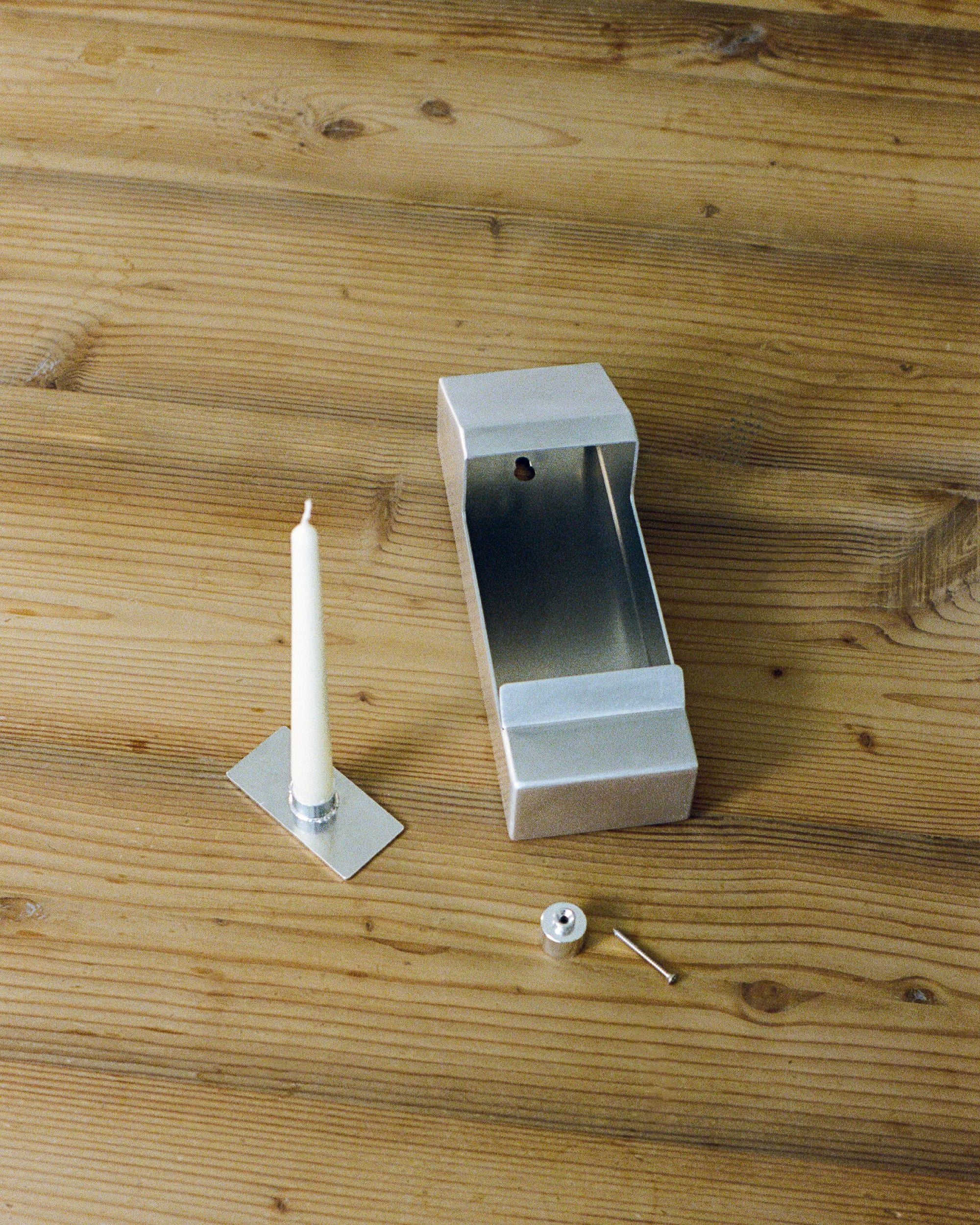 The components of the candle holder by PARCTA on wooden table. 