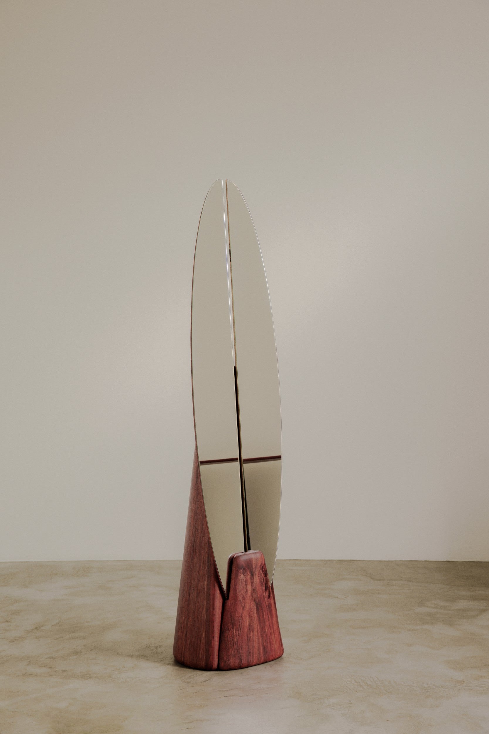 Floor standing mirror by Estudio Prosa on a neutral background with concrete flooring.
