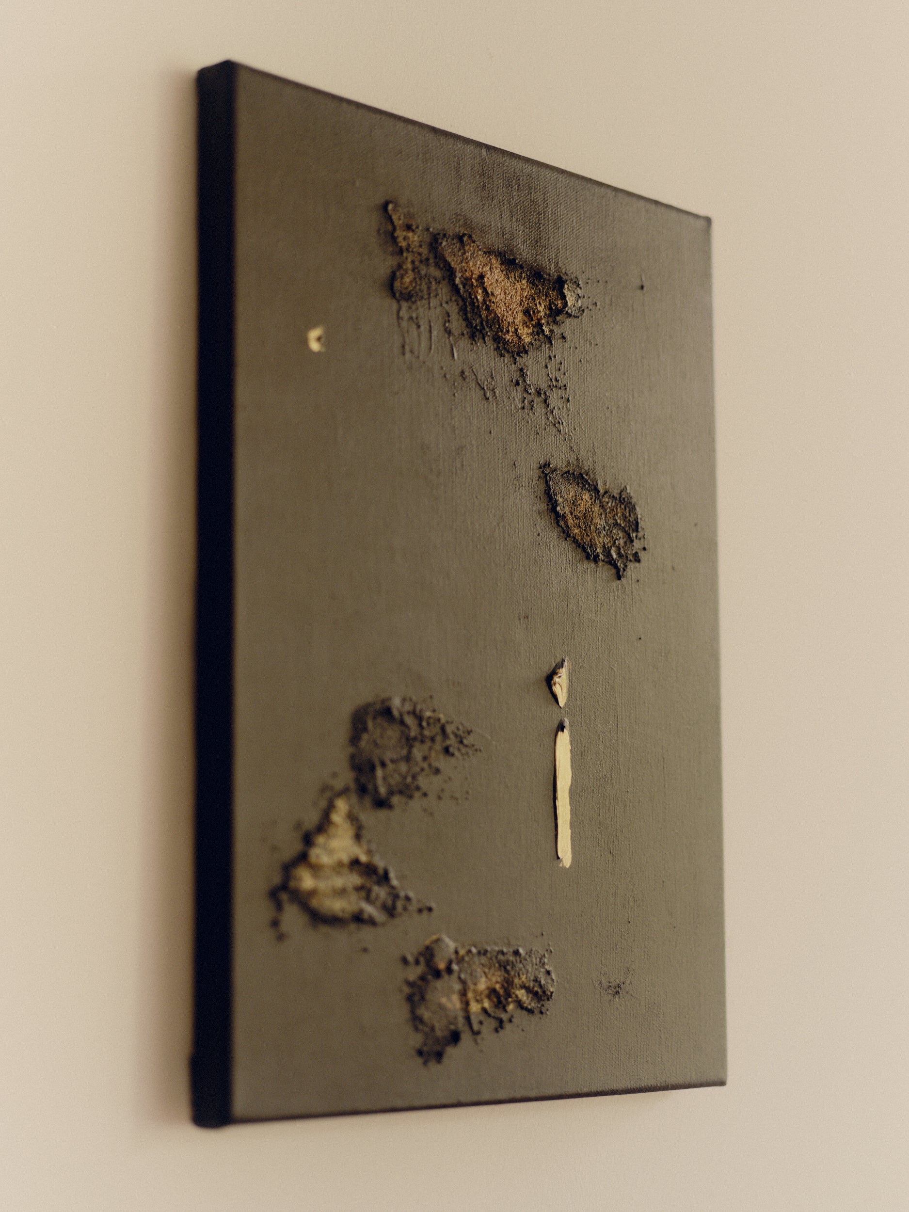 Gold and brown decorative abstract wall art on a white wall by Noelia Hobeika.