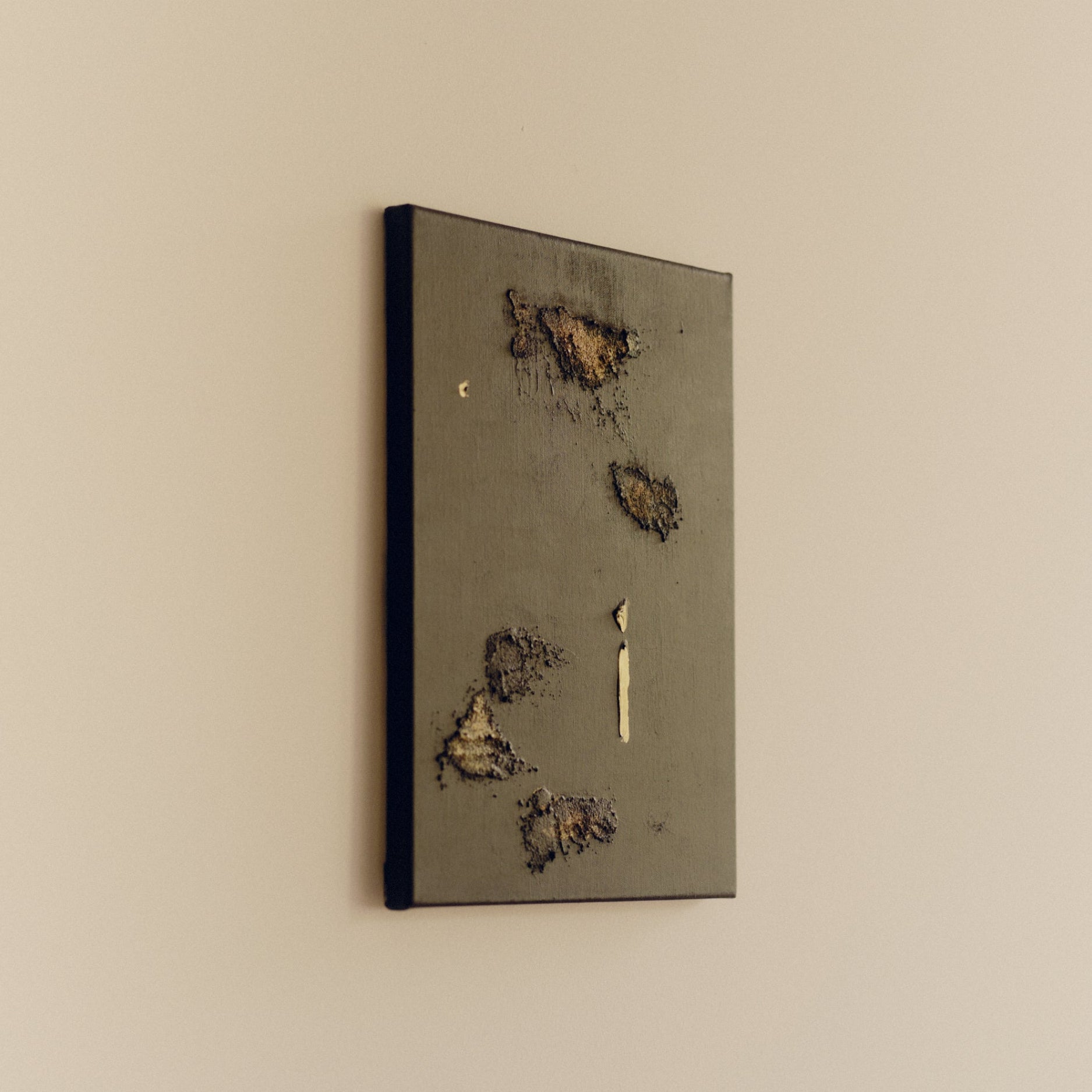 Gold and brown decorative abstract wall art on a white wall by Noelia Hobeika.