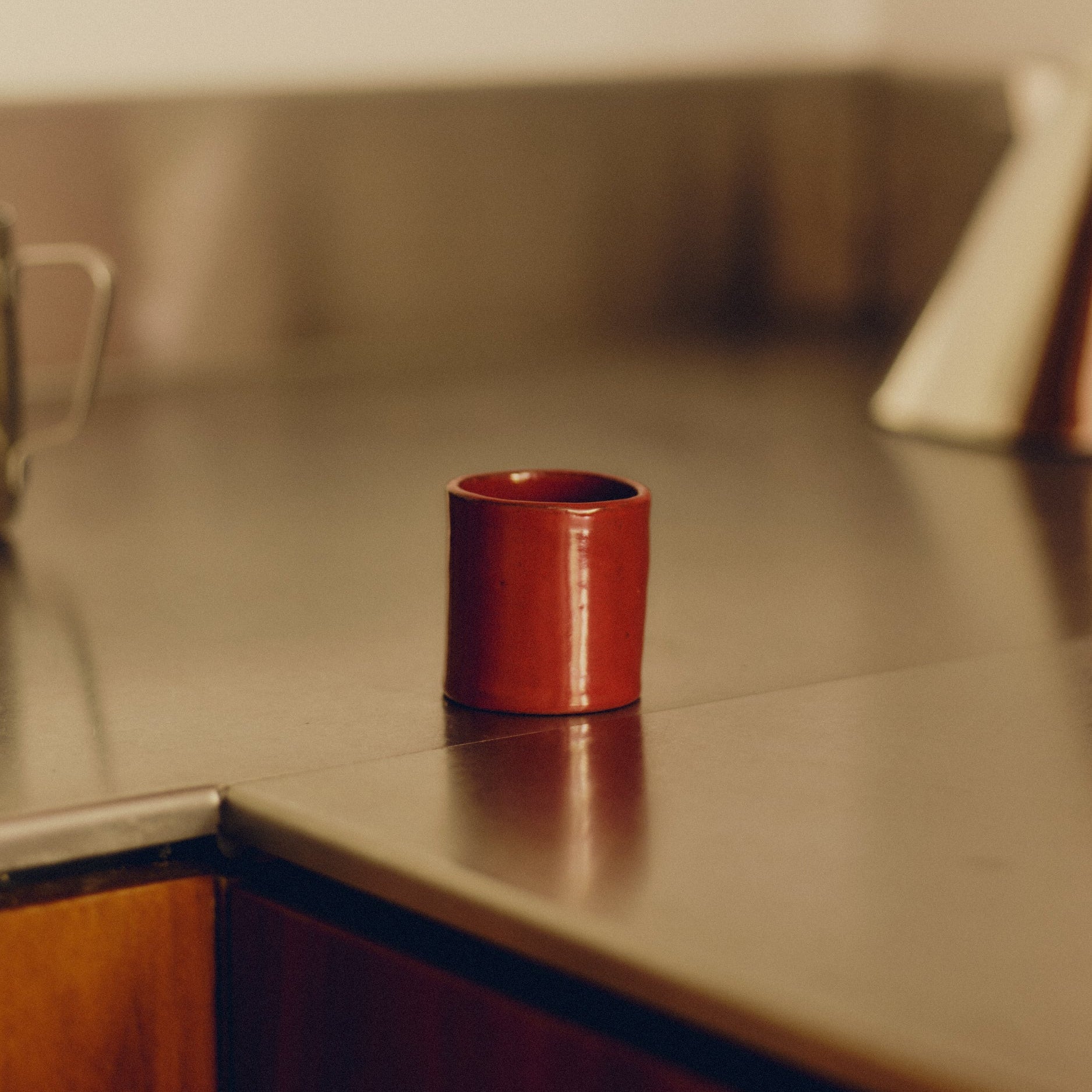 Red espresso cup by klangnapha on a stainless steel kitchen counter.