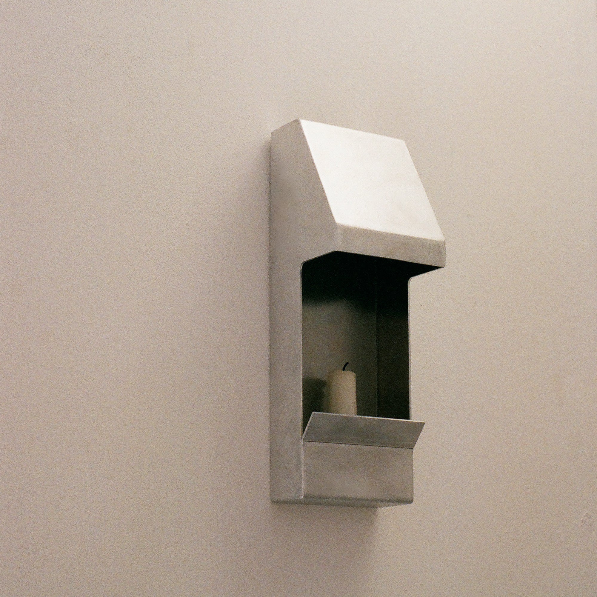 Candle holder by PARCTA with an unlit candle inside on a neutral background.