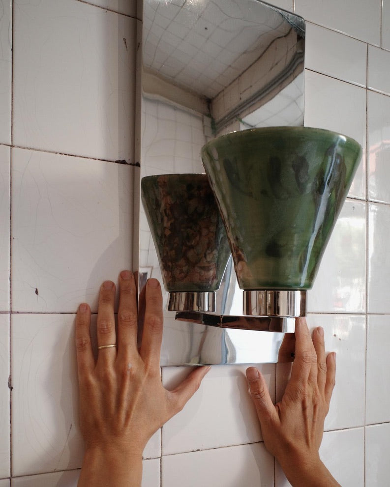 Marta Cypel placing the Vetra Lamp on a white tiled wall.