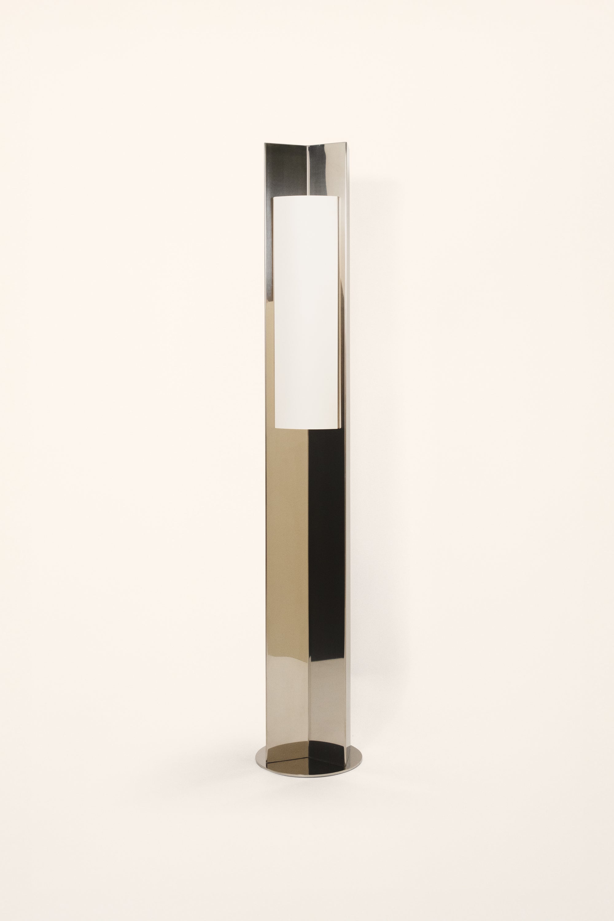 Polished steel foot lamp with paper diffuser by Violaine d'Harcourt on a white background with light off.