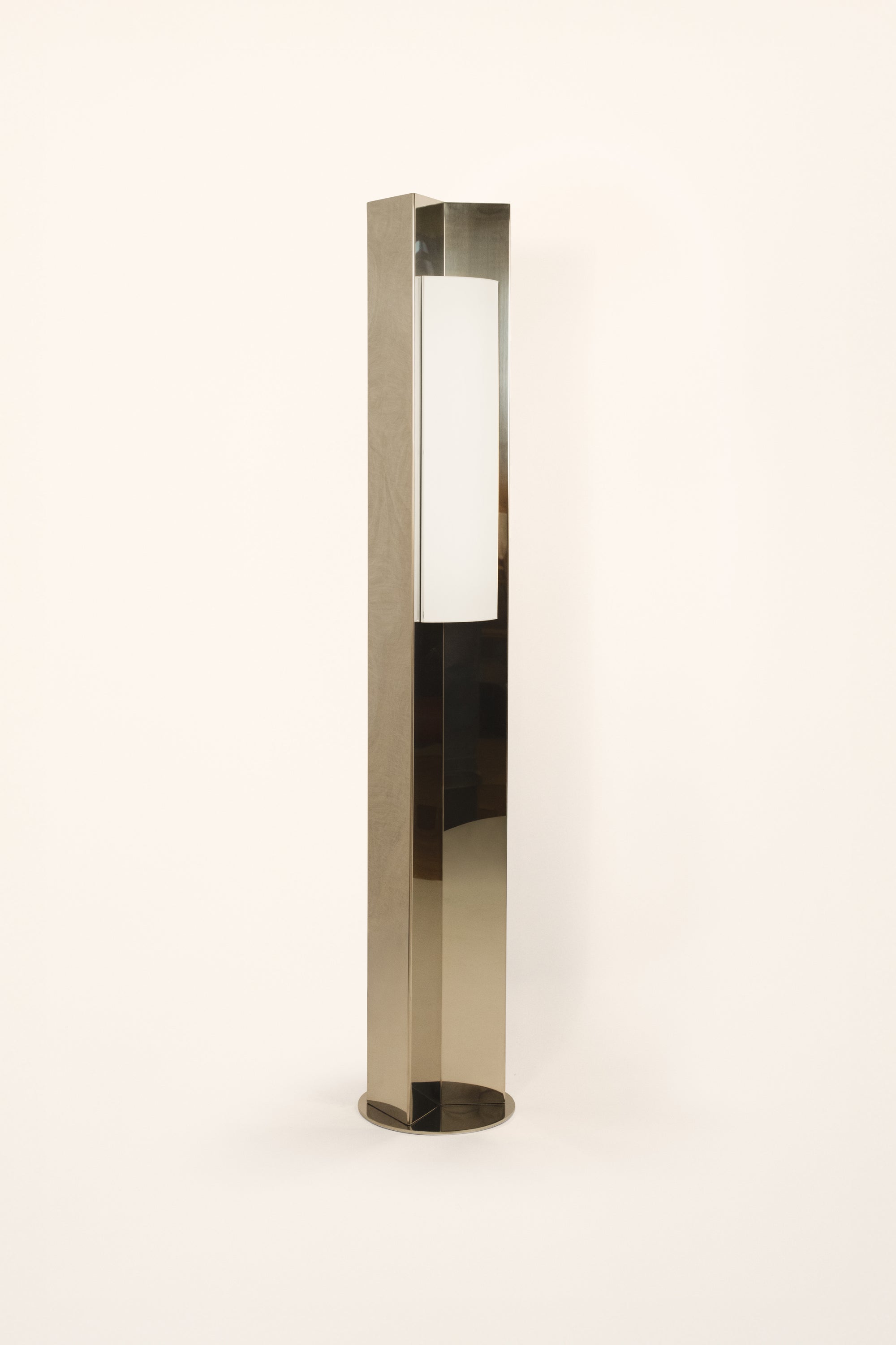 Polished steel foot lamp by Violaine d'Harcourt with paper diffuser on a white background with light off.