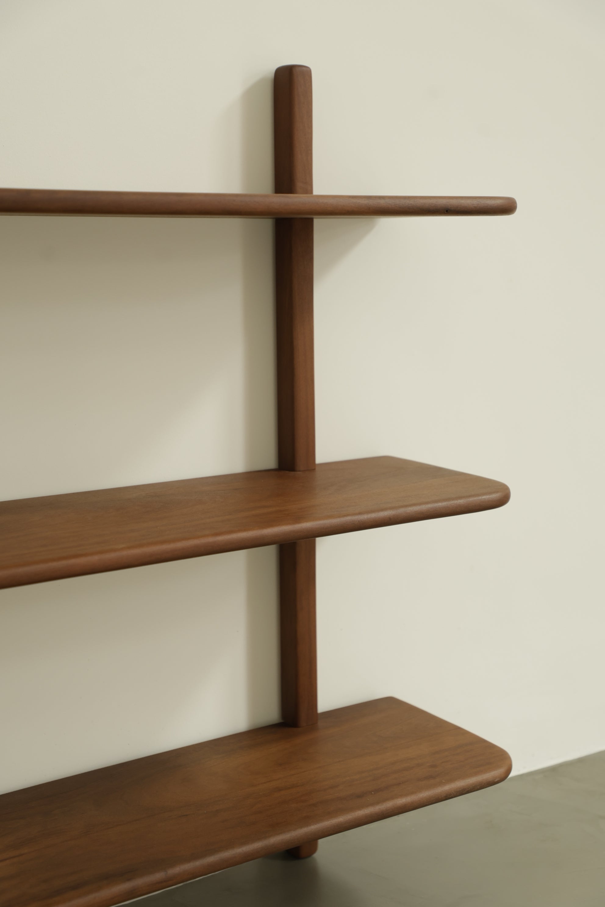 Wooden bookshelf by Estudio Prosa on a neutral wall.