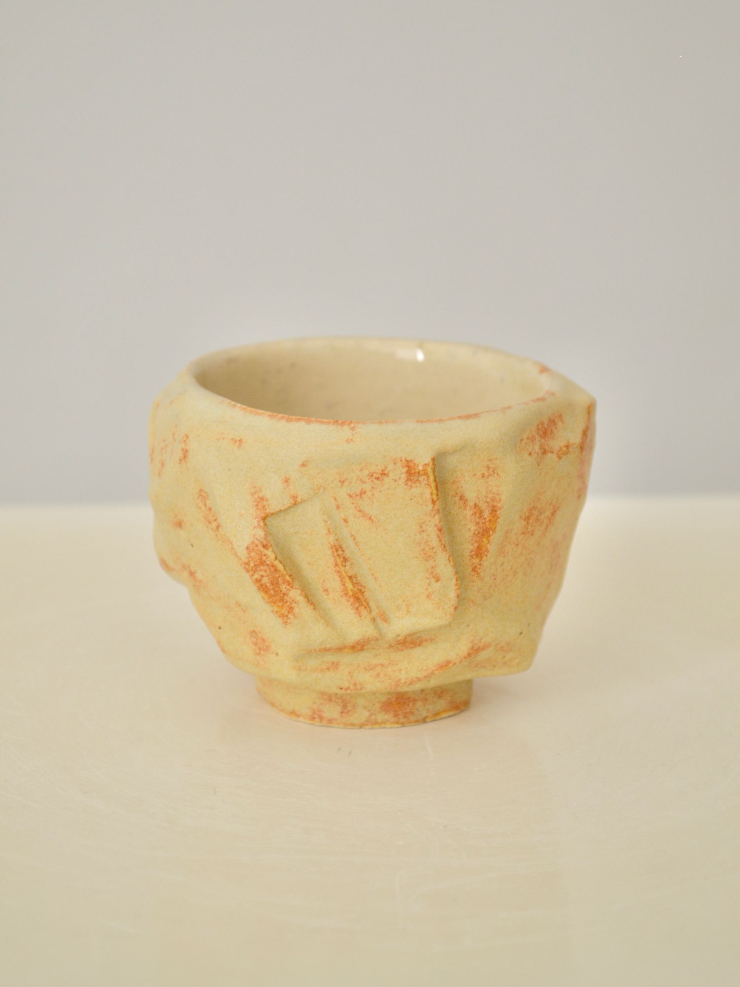 A sand coloured coffee cup by Zeynep Boyan on a neutral background.