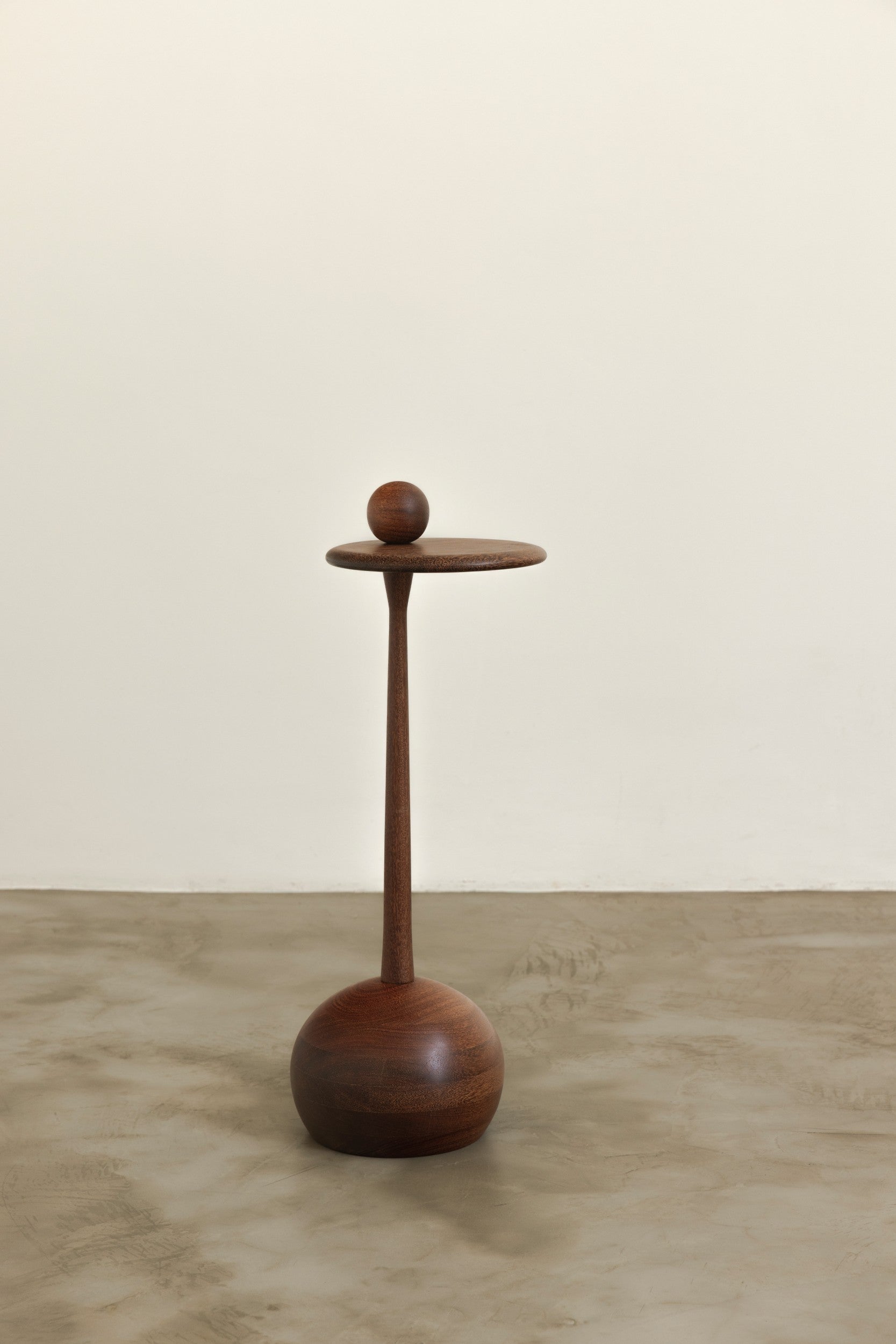 Wooden side table on a neutral background by Estudio Prosa.