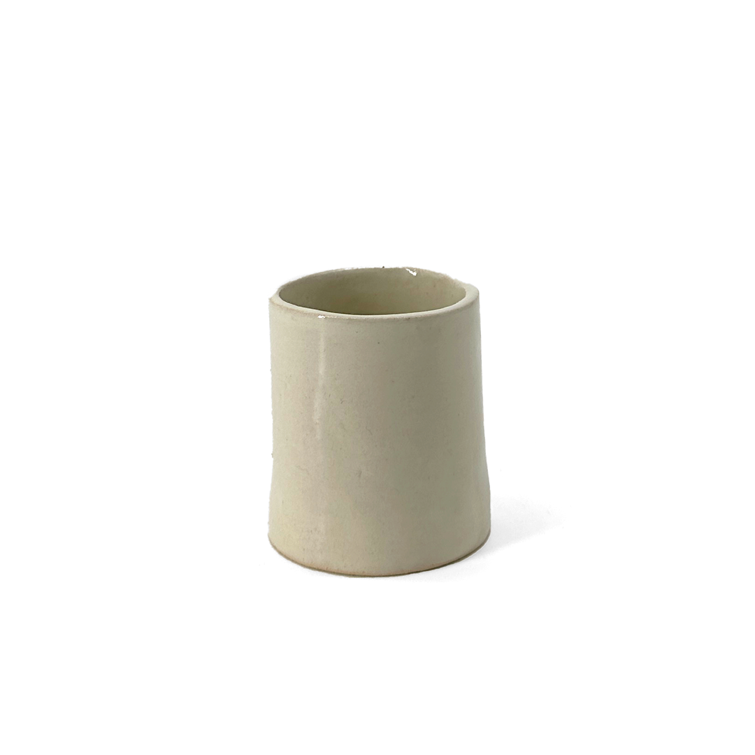 Ivory, glossy ceramic espresso cup by klangnapha on a white background.