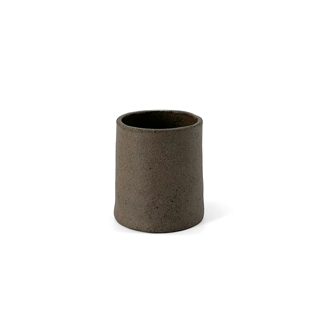 Dark grey, matte ceramic espresso cup by klangnapha on a white background.