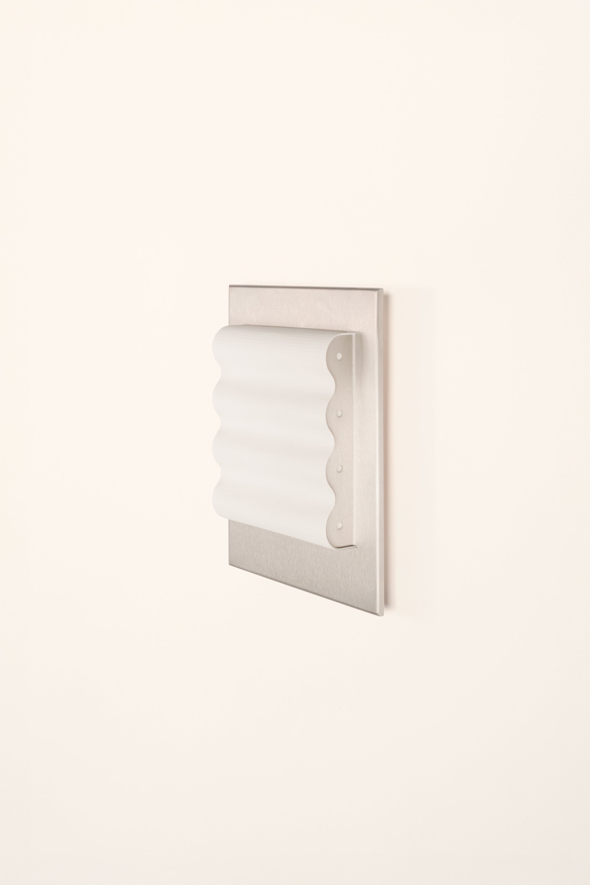 Framed wall light fixture in raw stainless steel with a paper shade by Violaine d'Harcourt on a white background with light off.