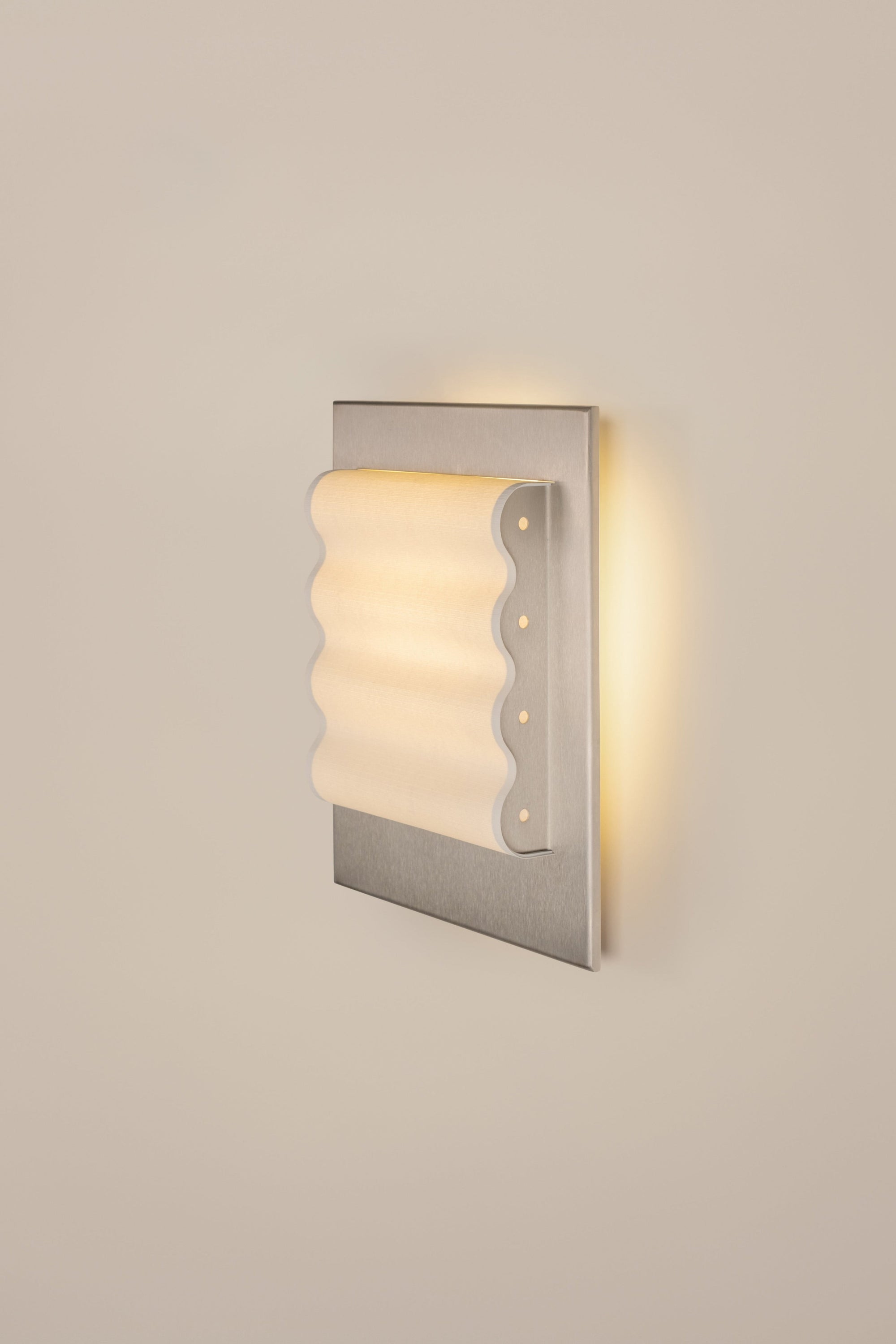 Violaine D'harcourt wall-mounted light fixture with ribbed shade on a beige wall