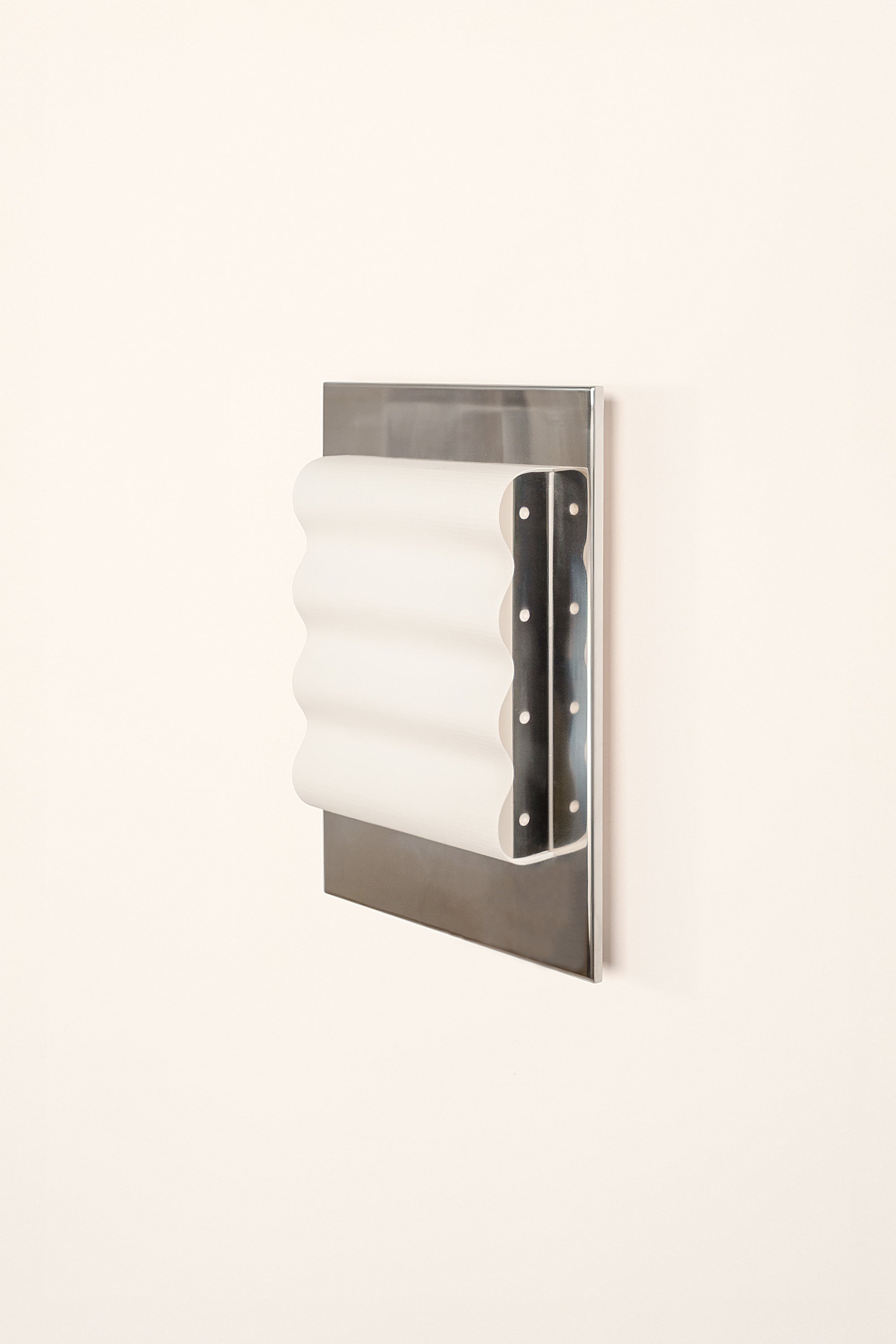 Framed wall light fixture in polished stainless steel with a paper shade by Violaine d'Harcourt on a white background with light off.