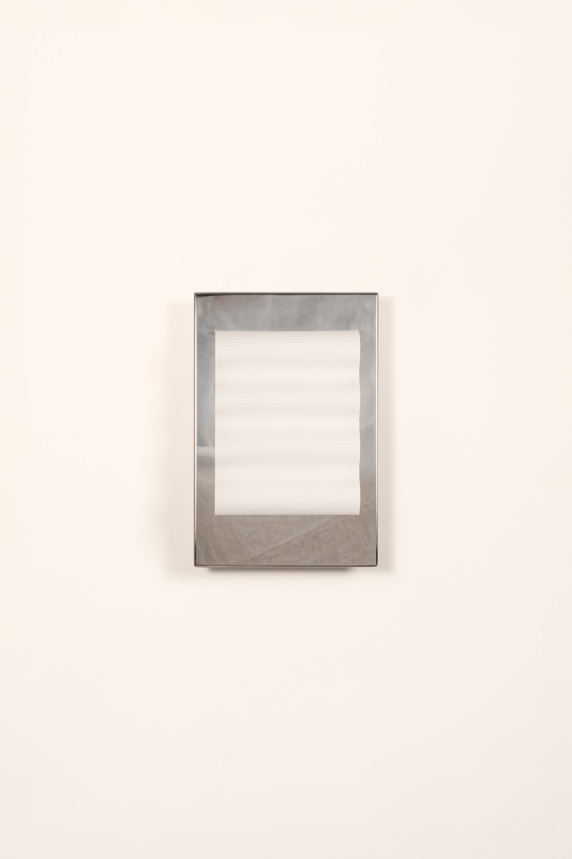 Framed wall light fixture in polished stainless steel with a paper shade by Violaine d'Harcourt on a white background with light off.