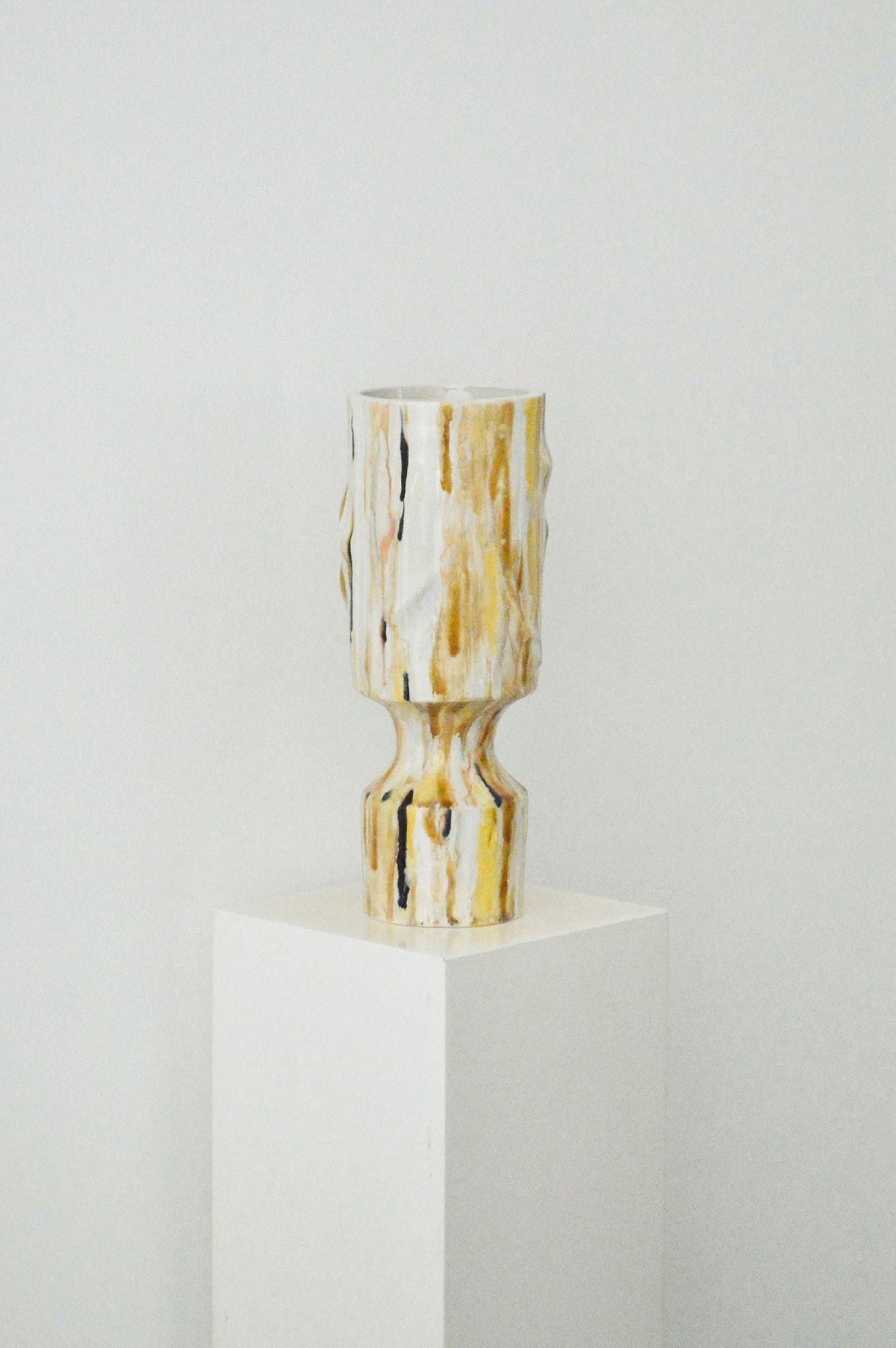 Decorative glazed vase by Zeynep Boyan on a white plinth with a white background. 