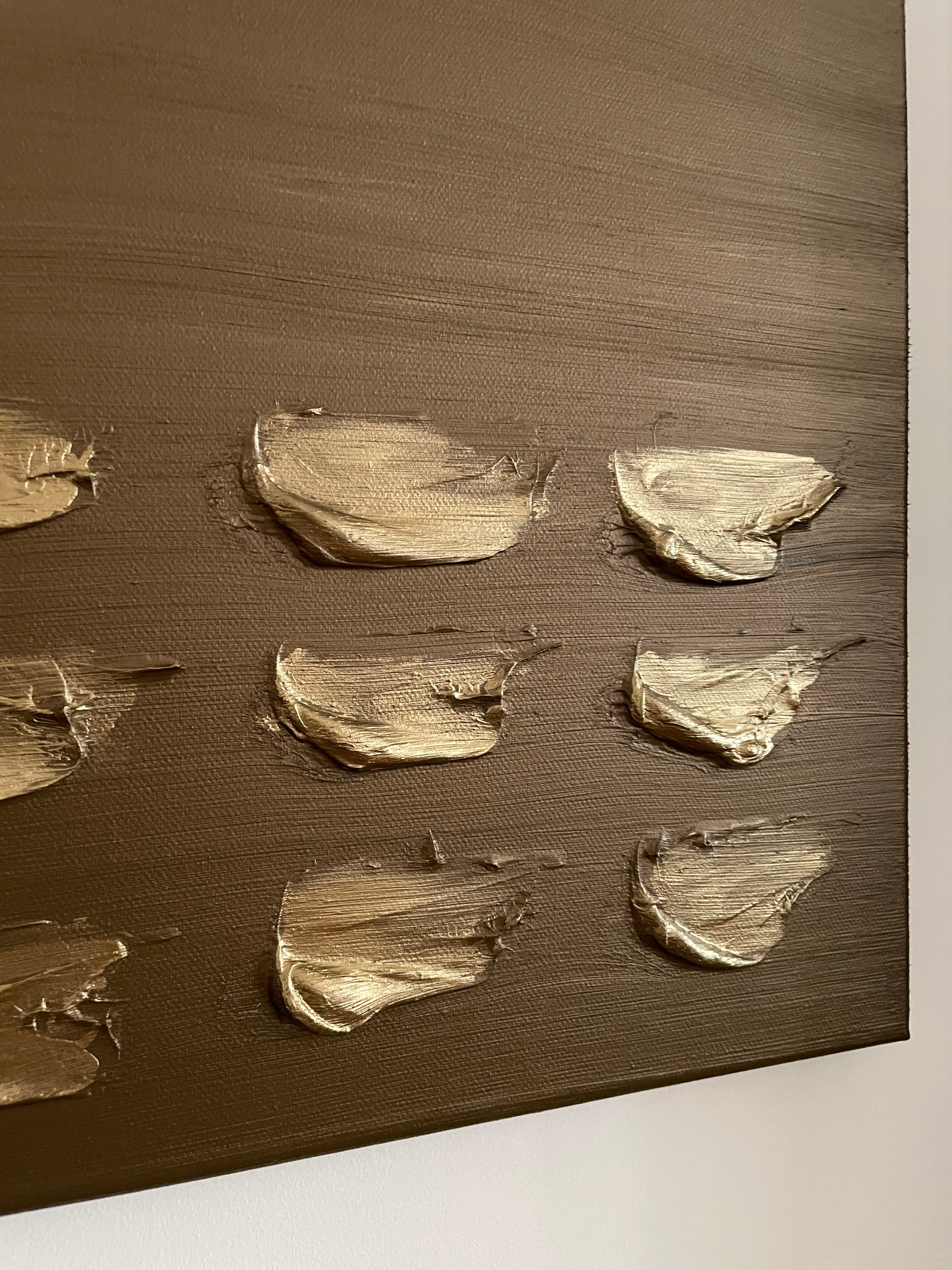 Close up of gold paint swatches on a gold and brown canvas abstract painting by Noelia Hobeika.