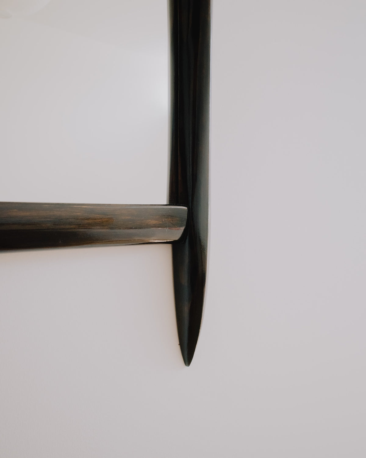 Close up of Glade mirror by Calum Stevens hanging on a neutral wall.