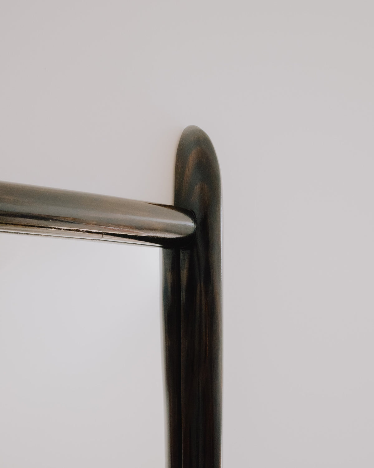 Close up of Glade mirror by Calum Stevens hanging on a neutral wall.