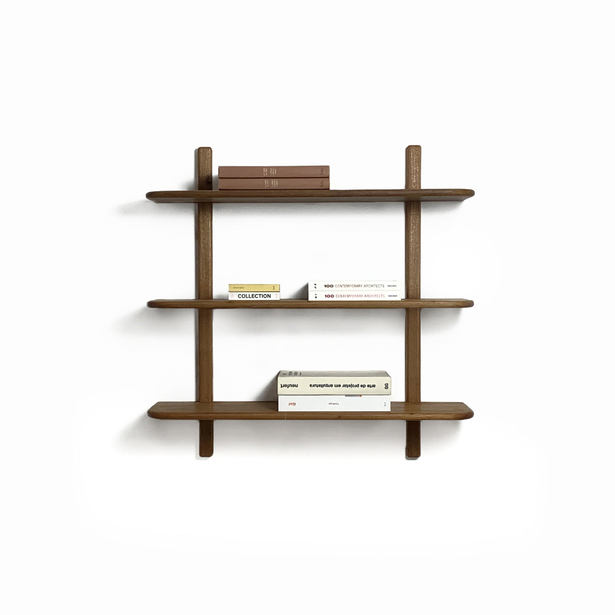 Wooden bookshelf by Estudio Prosa with books on a neutral wall.