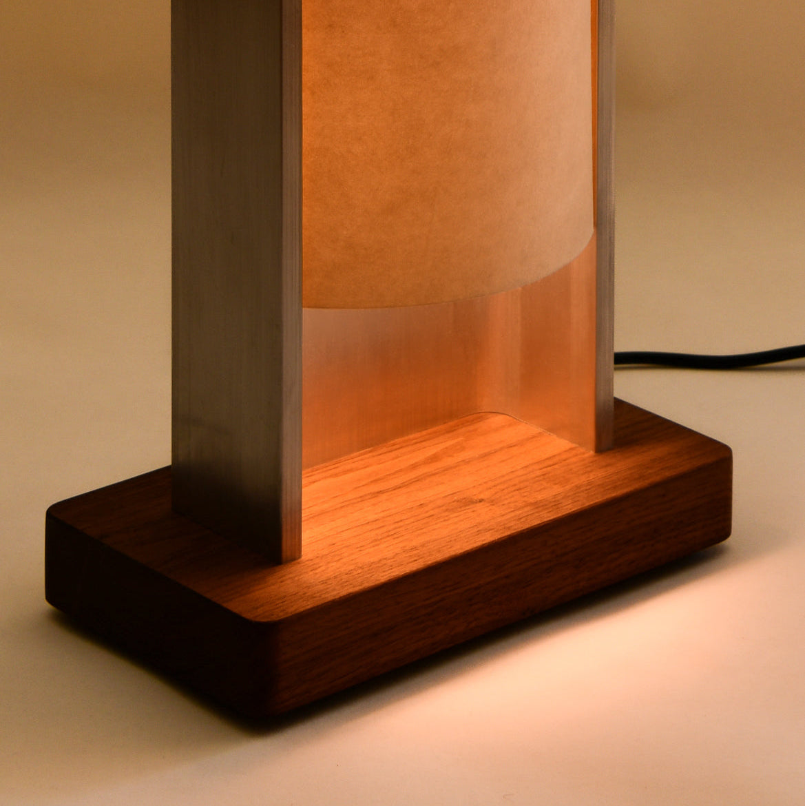 Close up of floor lamp by PARCTA with the light on, on a neutral background.