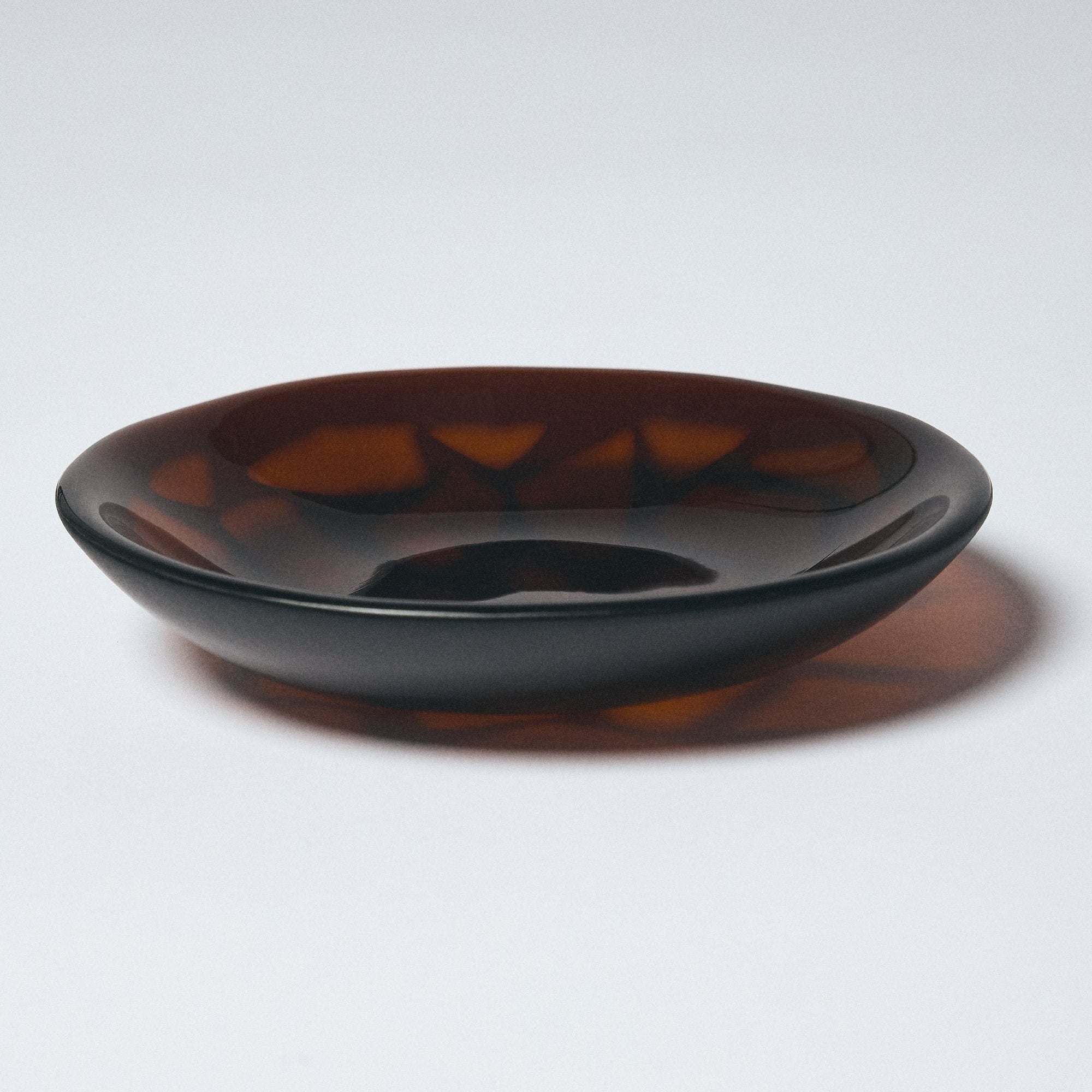 Dark amber glass bowl by Savoia Everything on a white background.