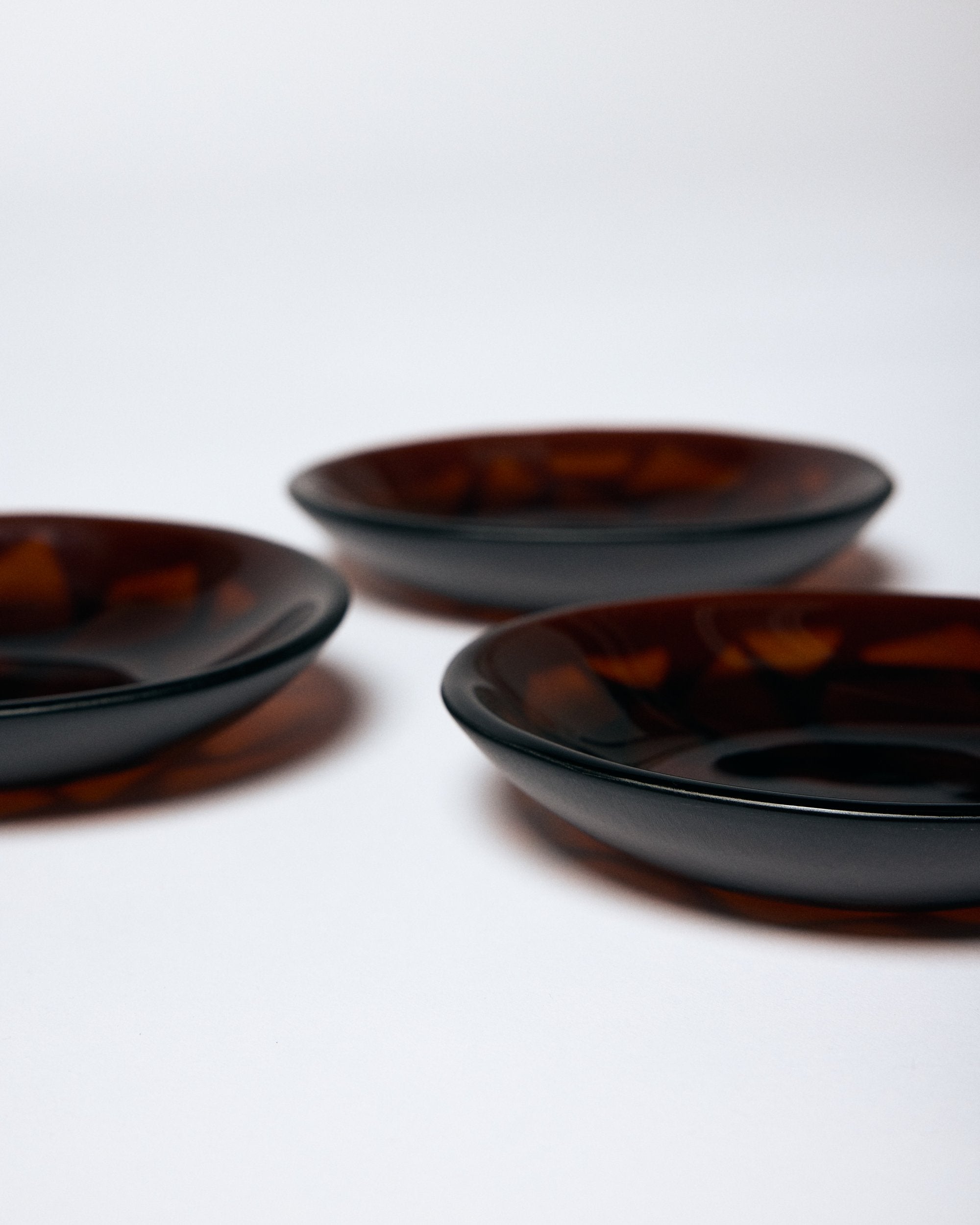 Three dark amber glass bowls by Savoia Everything on a white background.