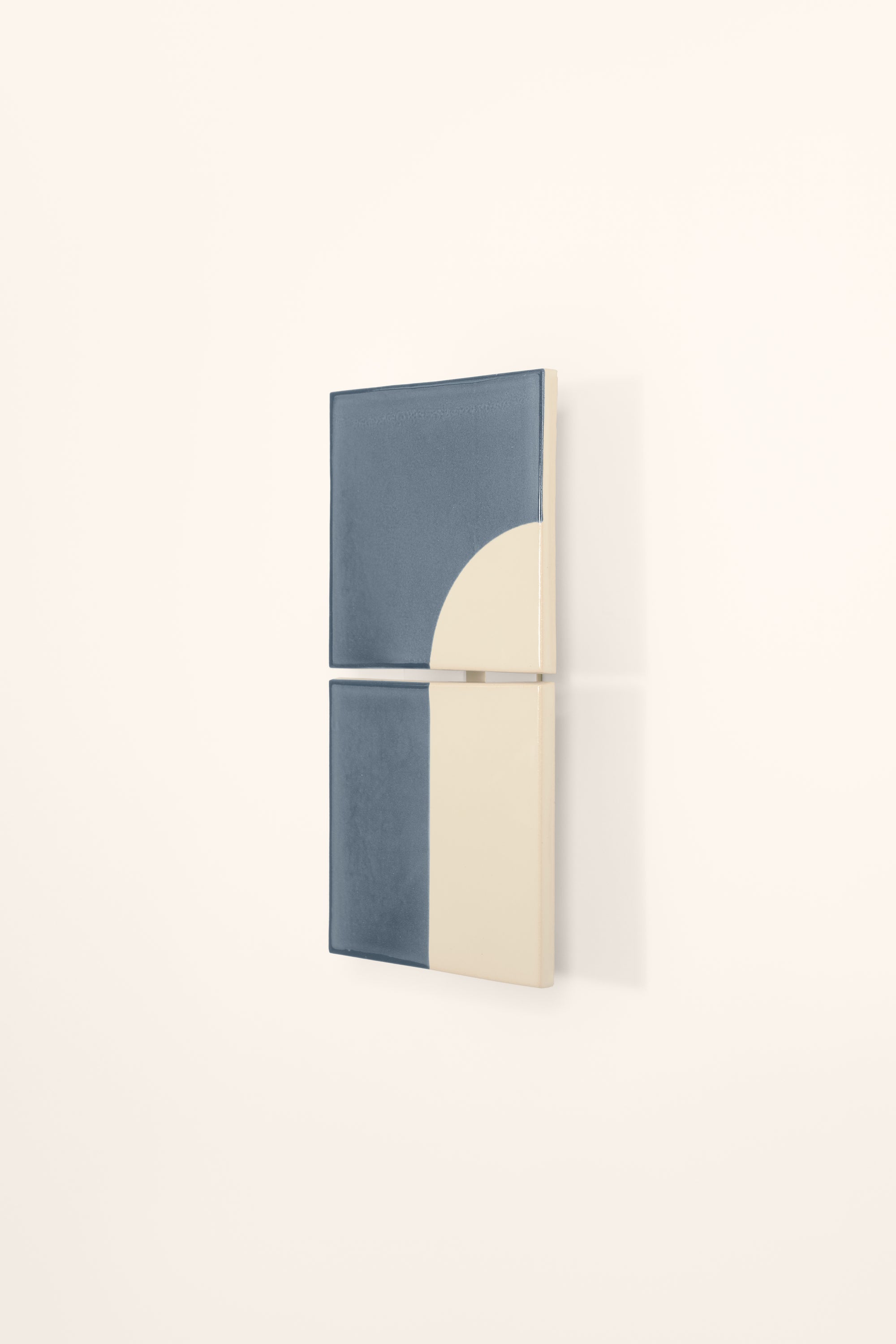 Wall-mounted light fixture by Violaine d'Harcourt with the light off. The design is a geometric pattern in blue and white with a neutral background.