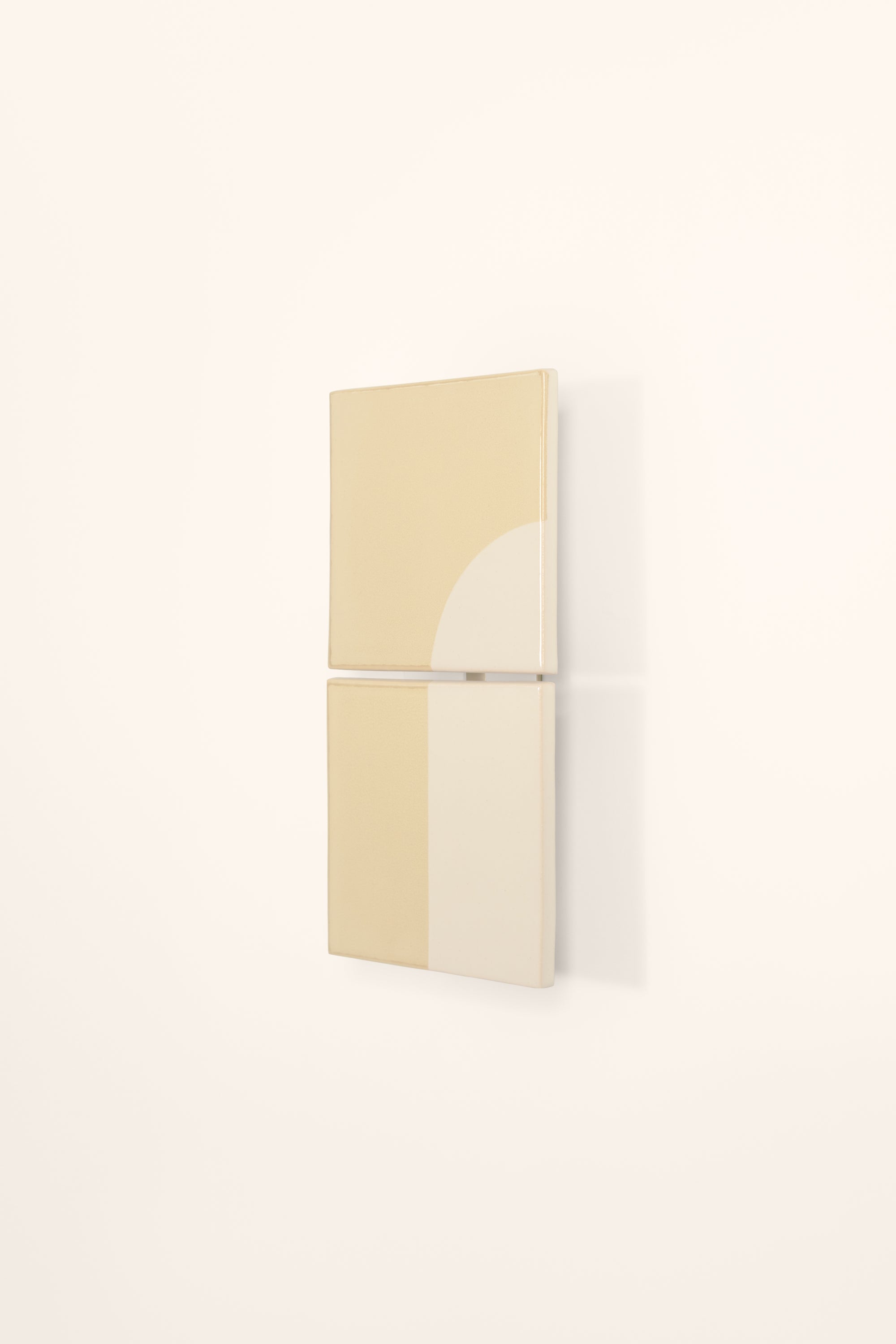 Wall-mounted light fixture by Violaine d'Harcourt with the light off. The design is a geometric pattern in cream and white with a neutral background.