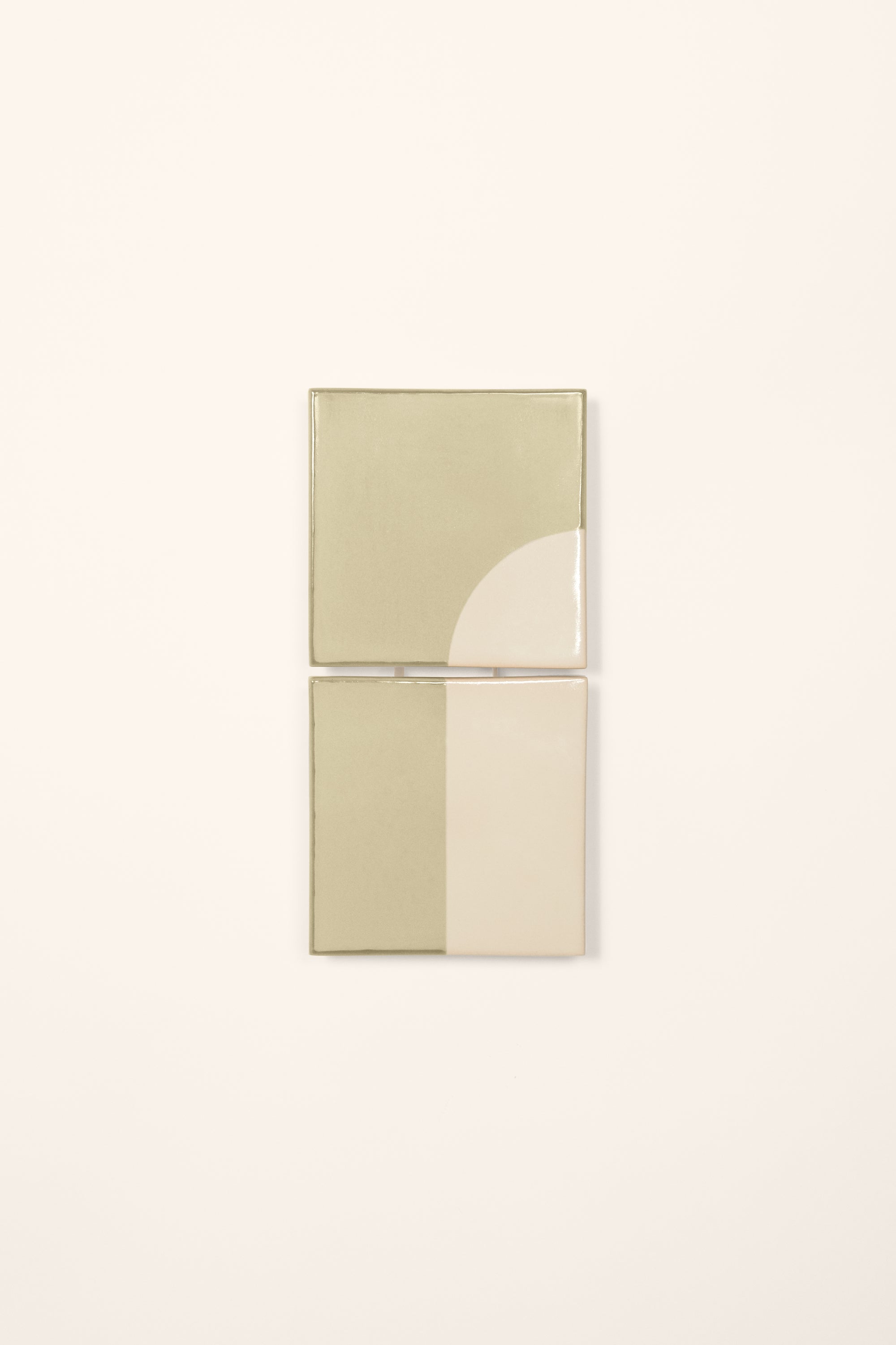 Wall-mounted light fixture by Violaine d'Harcourt with the light off. The design is a geometric pattern in green and white with a neutral background.