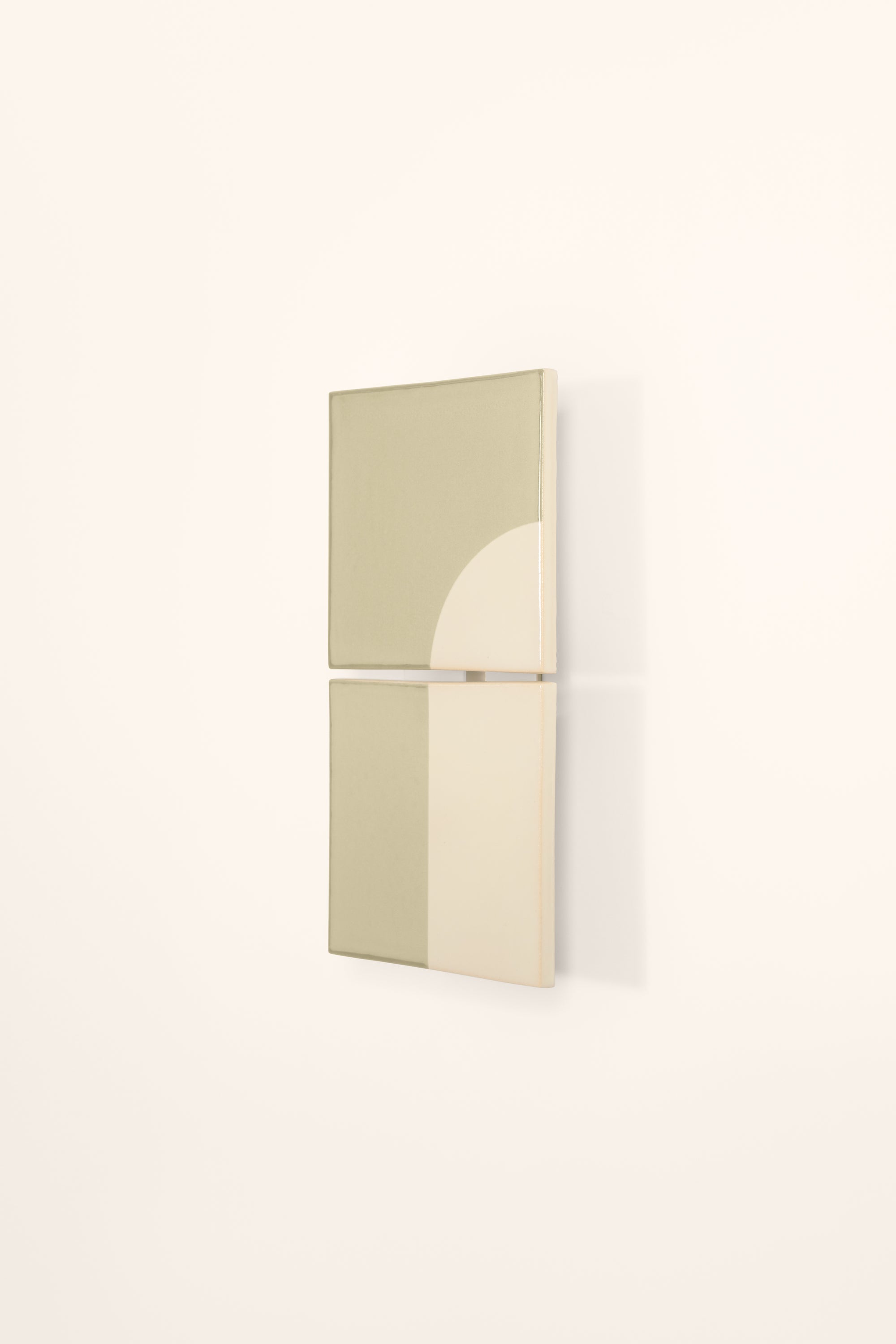 Wall-mounted light fixture by Violaine d'Harcourt with the light off. The design is a geometric pattern in green and white with a neutral background.