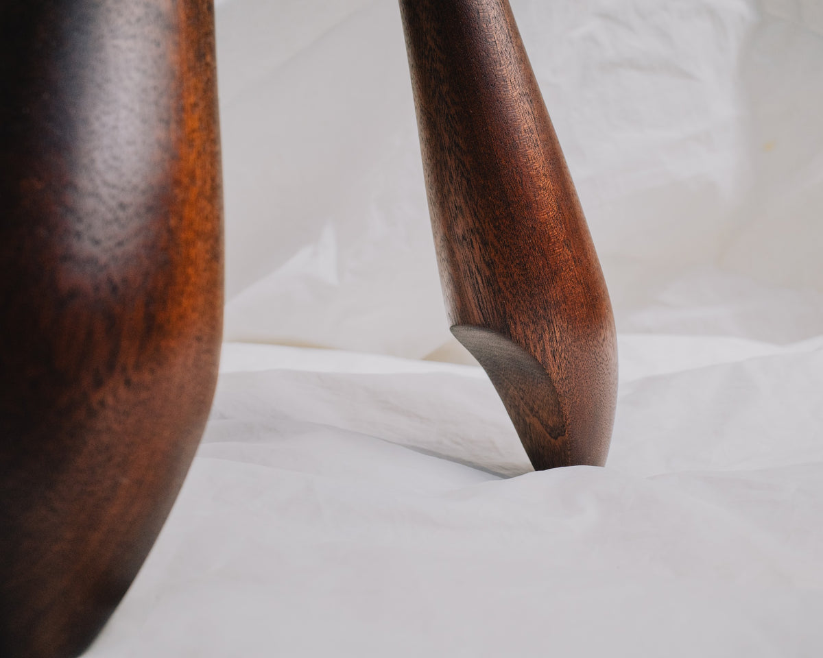Close up of legs on stool in sapele wood by Calum Stevens on neutral background.