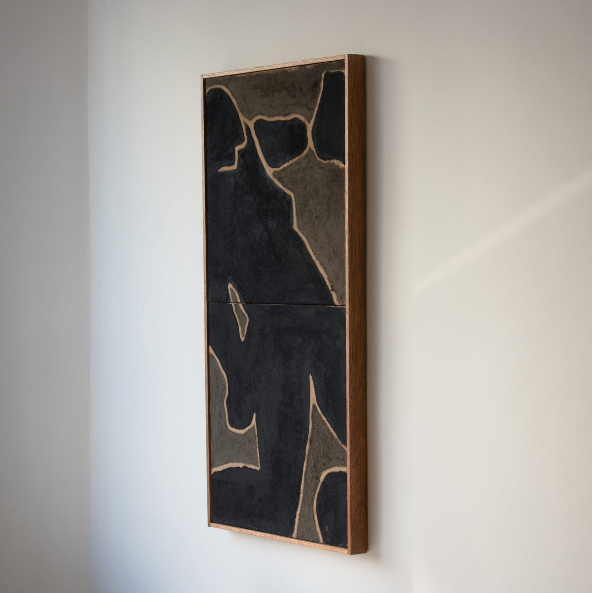 Original abstract wall art by Marcsen in black and earthy green tones housed in a vertical wooden frame and displayed on a neutral wall.